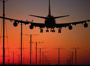 View of an airplane landing in sunset. If you need further assistance, call 800-853-1351 or email answers@bts.gov.