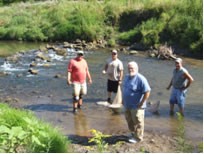 Photo of people standing in a creek.