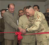 Major General David Petraeus and the new Interim Mayor Ghamin Al Basso cut the ribbon to open the new offices for the Interim Mayor in Mosul, Iraq on May 10, 2003.