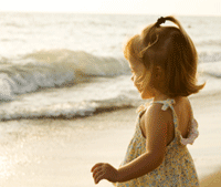 Picture of a little girl standing by the ocean.