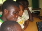 Older student helps younger student at the Ghana fab lab.