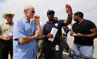 Homeland Security Secretary Michael Chertoff (left) being briefed by Eric Smith (right) FEMA Assistant Administrator for Logistics at the Reliance Center Commodity Staging Site (RSA) in Houston. The RSA is dispatching trucks of ice, bottled water, and Meals Ready to Eat (MRE) to Points of Distribution (POD) in the Houston area in the aftermath of Hurricane Ike. Mike Moore/FEMA