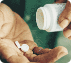 Photo of someone taking two aspirin out of a medicine bottle