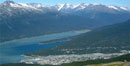 Aerial Photo of Skagway showing the blue waters of the Taiya Inlet, snow-capped peaks and the little town dwarfed in the foreground