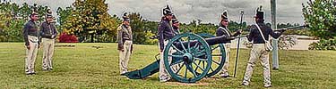 Park staff and volunteers dressed as first fort soldiers prepare to fire cannon