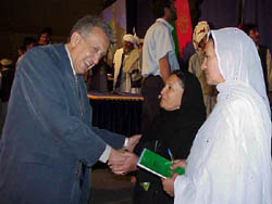 Special Representative of the U.N. Secretary-General, Lakhdar Brahimi (left) congratulates two women delegates to the Loya Jirga, which voted Thursday to continue the rule of Hamid Karzai, now Chairman of the Interim Authority. Mr. Karzai won a landslide victory against two challengers to be chosen as the President of the Transitional Authority for up to two years