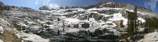 Lake-filled cirque surrounded by snow-covered granite walls