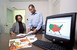 Photo: A research leader (left), and mathematical statistician, review data for the community nutrition mapping project. Link to photo information