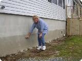 Homeowner points to height of foundation before elevation.