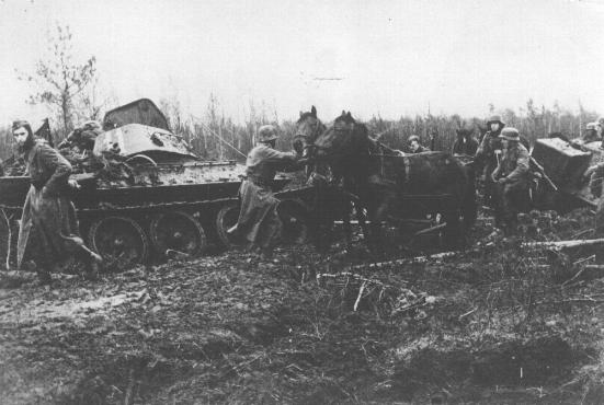 A German army column struggles through the mud, past a destroyed Soviet tank.  Nevel, Soviet Union, fall 1943.