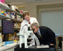 President George W. Bush looks into a microscope.