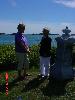 Project consultant and resident Marsha Ismail (l) and Selectwoman Gloria Feeney (r) stand near wild rose bushes and tombstones above Moosabec Beach. 