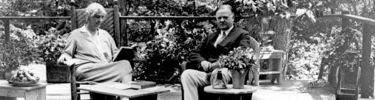 Herbert & Lou Henry Hoover seated on porch