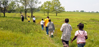 A ranger leads a group of young students across Big Meadows.