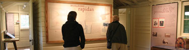 Visitors study the interpretive exhibit at historic Rapidan Camp.