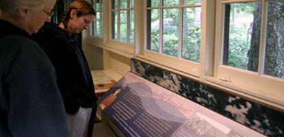 Visitors read informative exhibit panels at historic Rapidan Camp.