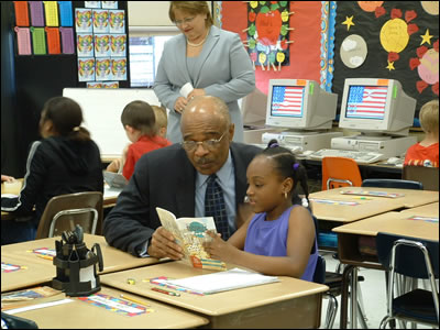 Secretary Paige helps a student with her assignment while visiting Larimore Elementary School in metro St. Louis, Missouri.