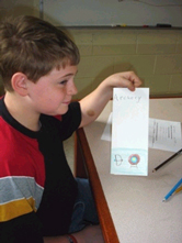 Eric Bowler, a 6th-grader at John F. Kennedy Middle School in Florence, Massachusetts, works on a brochure detailing his favorite physical activities--archery and tree climbing.