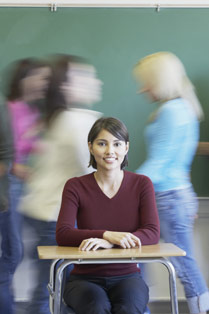 girl sitting with students moving behind her