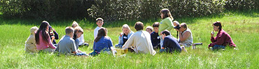 Students sit on the lawn in front of the 19th-century Carroll Homestead.