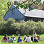 A group of students sits in front of the 19th-century Carroll Homestead.