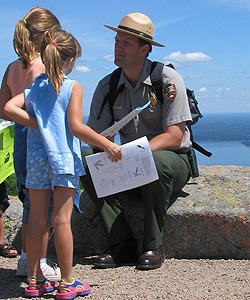 A park ranger talks to two young girls atop Cadillac Mountain.