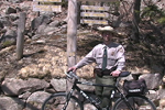 Park ranger with bike stands near carriage road sign.