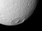 Cassini looks into the 245-kilometer (150-mile) wide crater Melanthius in this view of the southern terrain on Tethys. The crater possesses a prominent cluster of peaks in its center which are relics of its formation