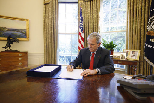 President George W. Bush signs the Emergency Economic Stabilization Act of 2008 in the Oval Office Friday, Oct. 3, 2008, at the White House. White House photo by Eric Draper