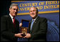 President George W. Bush is presented with an honorary FBI Special Agent credential by FBI Director Robert Mueller Thursday, Oct. 30, 2008, at the graduation ceremomy for FBI special agents in Quantico, Va. White House photo by Joyce N. Boghosian
