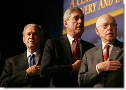 President George W. Bush joins FBI Director Robert Mueller and U.S. Attorney General Michael Mukasey during the playing of the national anthem Thursday, Oct. 30, 2008, at the graduation ceremony for FBI special agents in Quantico, Va. White House photo by Joyce N. Boghosian