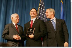 President George W. Bush and U.S. Attorney General Michael Mukasey congratulate FBI special agent graduate Richard Brooks, center, after he is presented with the Director's Leadership Award Thursday, Oct. 30, 2008, during the graduation ceremony for FBI special agents in Quantico, Va. White House photo by Joyce N. Boghosian
