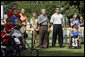 President George W. Bush listens to the National Anthem before a Tee Ball game on the South Lawn of the White House between the District 12 Little League Challengers from Williamsport, PA and the West University Little League Challengers from Houston, Texas on Sunday July 24, 2005.  White House photo by Paul Morse