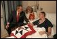 President George W. Bush visits with USMC Lance Corporal Sean Phillips and his mother, Sharon, at the National Naval Medical Center in Bethesda, Md., Saturday, Dec. 11, 2004. Cpl. Phillips was injured in Operation Iraqi Freedom. While recovering in Germany, he received a donated quilt from supporters in Texas. Given to wounded soldiers returning to the states, the quilts come from groups and individuals from all over America. The President added his own Texas signature to the quilt. White House photo by Paul Morse