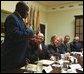 President George W. Bush listens to Robert Sutton, left, a graduate of the Prison Fellowship Ministries InnerChange Freedom Initiative, during a roundtable discussion in the Roosevelt Room Wednesday, June 18, 2003. The initiative is is part of the Texas Department of Criminal Justice System and the new prisoner reentry and treatment program proposed by the Department of Justice.   White House photo by Tina Hager