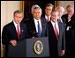 Accompanied by a bipartisan group of legislators, President George W. Bush signs H.J. Resolution 114 authorizing the use of force against Iraq in the East Room Wednesday, Oct. 16. "The resolution I'm about to sign symbolizes the united purpose of our nation, expresses the considered judgment of the Congress, and marks an important event in the life of America," said President Bush. Standing next to the President are Secretary of State Colin Powell, center, and Secretary of Defense Donald Rumsfeld, right.  