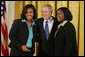 President George W. Bush congratulates Carrietha "Katie" Ball and her sister, Karl'Nequa Ball of Jackson, Miss., after awarding them the President's Volunteer Service Awards during a White House celebration of African American History Month. White House photo by Paul Morse