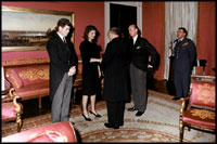 With her brother-in-law Edward Kennedy at her side, Jacqueline Kennedy greets guests in the Red Room following the funeral for her husband, President John Kennedy.