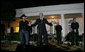 With Kenny Chesney listening in, President George W. Bush addresses guests in the Rose Garden Wednesday, July 16, 2008, following the Social Dinner in Honor of Major League Baseball. The President told his audience, "“It doesn’t get much better than this – country music in the Rose Garden and celebrating baseball.” White House photo by Chris Greenberg