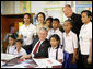 President George W. Bush poses for a photo with children and staff members, including Father Joseph Maier, during his visit Thursday, Aug. 7, 2008, to the Human Development Foundation-Mercy Centre, a non-profit organization to help educate and improve the health and welfare of poor children in Bangkok. White House photo by Eric Draper