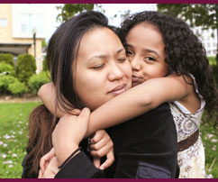 A child comforts her mother with a hug