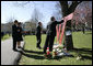 President George W. Bush signs a large Virginia Tech emblem, as the President and Mrs. Laura Bush stop to pay their respects at a campus memorial following the Convocation Tuesday, April 17, 2007 in Blacksburg, Va., honoring the shooting victims at Virginia Tech. The Bushes are accompanied by Governor Tim Kaine and his wife, Anne Holton. White House photo by Eric Draper