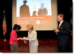 Mrs. Lynne Cheney hands out a copy of, “The Citizen’s Almanac,” during a special naturalization ceremony at the National Archives Tuesday, April 17, 2007, in Washington, D.C.  