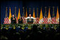 Pope Benedict XVI, joined on stage by Vice President Dick Cheney and Mrs. Lynne Cheney, gestures to the faithful Sunday, April 20, 2008 at a farewell ceremony for the Pope at John F. Kennedy International Airport in New York. White House photo by Shealah Craighead