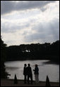 President George W. Bush talks with German Chancellor Angela Merkel and her husband, Joachim Sauer, Tuesday, June 10, 2008, during an early evening stroll near a lake on the grounds of the government guest house in Meseberg, Germany. White House photo by Eric Draper