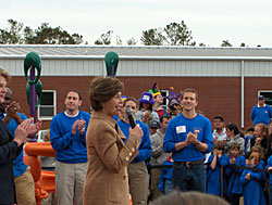 White House Fellows volunteer time in Louisiana to build a playground at a school devastated by Hurricane Katrina. First Lady Laura Bush speaks at the ribbon-cutting ceremony. 