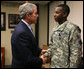 President George W. Bush shakes the hand of U.S. Army PFC Demario Hicks of Fort Stewart, Ga., Thursday, Dec. 20, 2007, after presenting him with a Purple Heart during his visit to Walter Reed Army Medical Center in Washington, D.C., where the soldier is recovering from injuries suffered in Operation Iraqi Freedom. White House photo by Joyce N. Boghosian