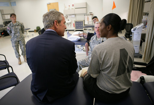 President George W. Bush speaks with a wounded soldier during his visit Thursday, Nov. 8, 2007 to the physical therapy and training area at the Center for The Intrepid at the Brooke Army Medical Center in San Antonio, Texas. White House photo by Eric Draper