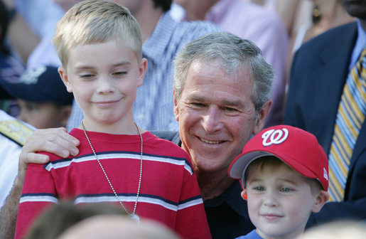 President George W. Bush poses for photos with two youngsters at the Tee Ball on the South Lawn: A Salute to the Troops game Sunday, Sept. 7, 2008, played by the children of active-duty military personnel. White House photo by Chris Greenberg