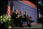 President George W. Bush shares a smile with Greensburg Schools Superintendent Darin Headrick, (left), and Greensburg High Principal Randy Fulton, during commencement ceremonies for the Greensburg High School graduating class of 2008. The town of Greensburg, KS was almost entirely destroyed when a tornado tore through the town one year ago today. White House photo by Chris Greenberg